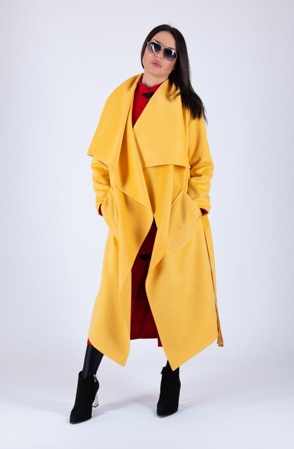 Coat VICTORIA - Front View: Yellow asymmetric coat with belt and two side pockets.