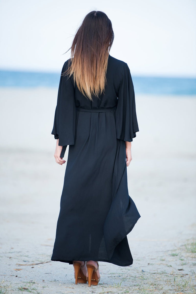 ASTRID Summer Maxi Dress - Image showing a model wearing a floral wrap-up maxi dress with wide sleeves and a belt closure. Back view